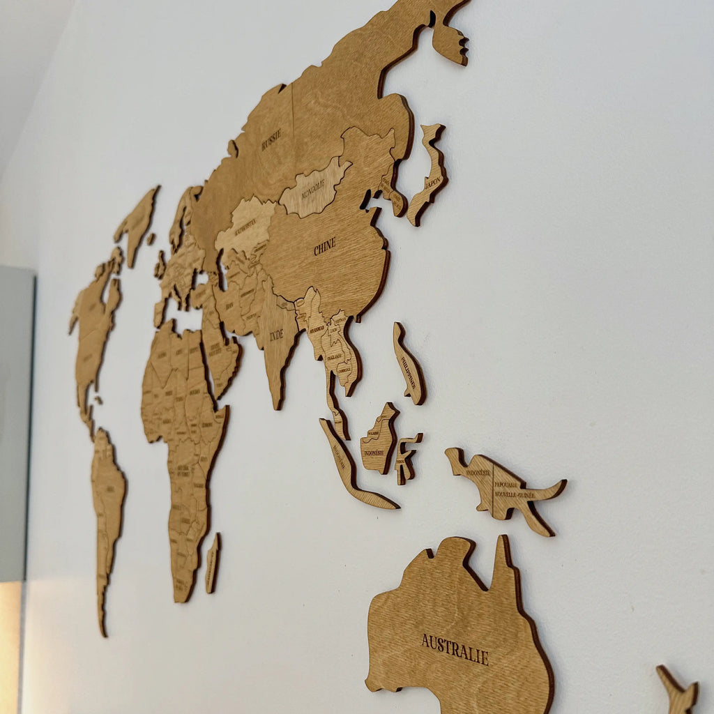 Carte du monde en bois accrochée à un mur blanc