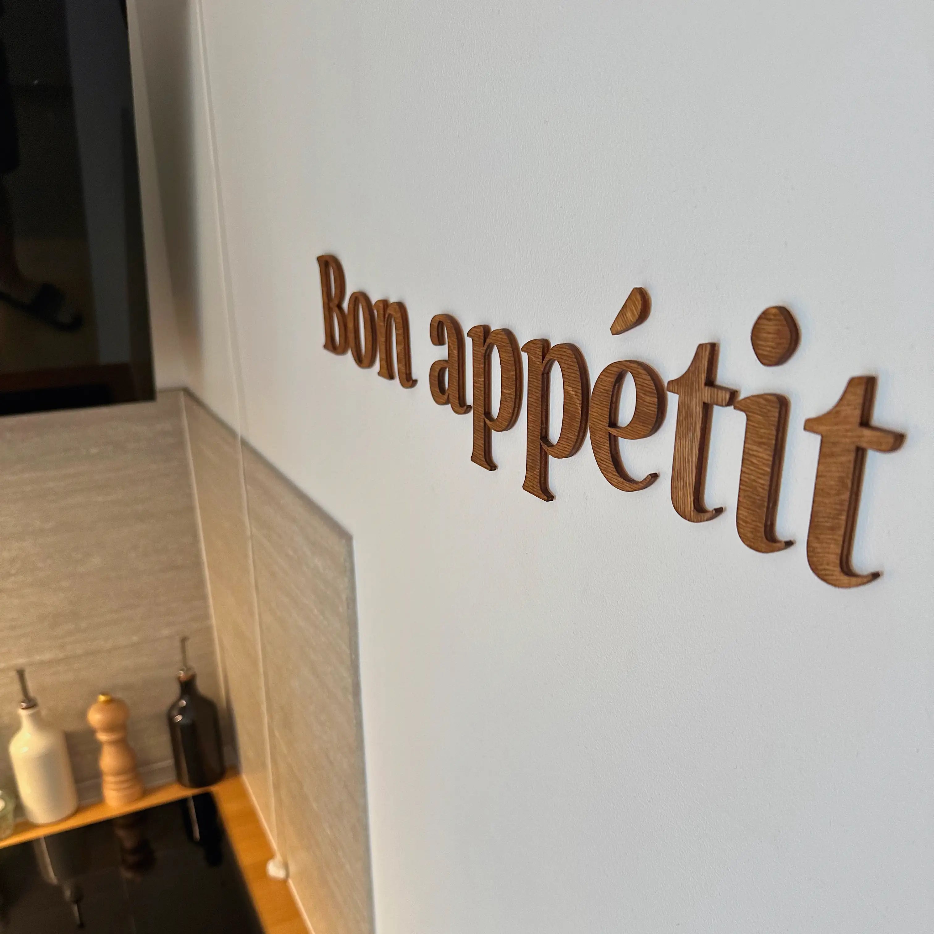Phrase murale en bois "Bon appétit" installée dans une cuisine