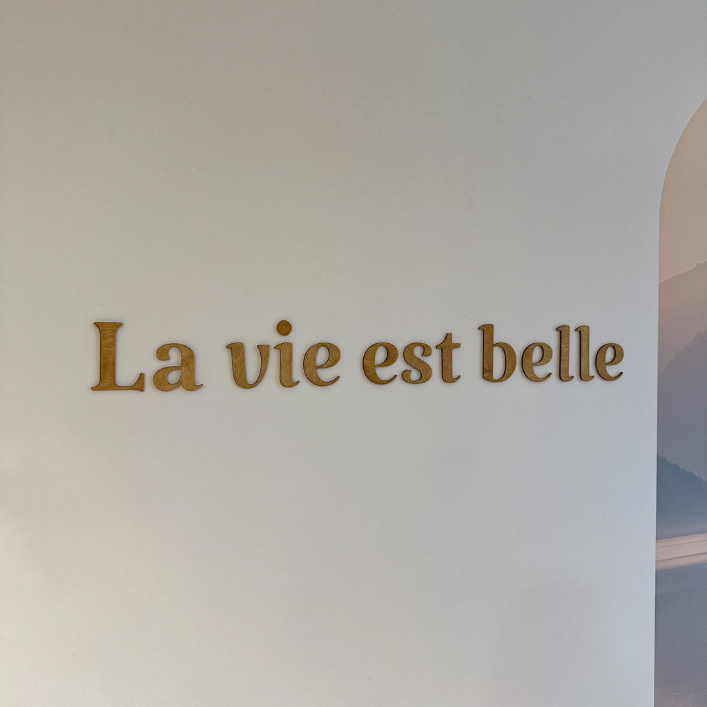 Phrase murale en bois "La vie est belle" installée dans un salon