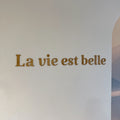 Phrase murale en bois "La vie est belle" installée dans un salon