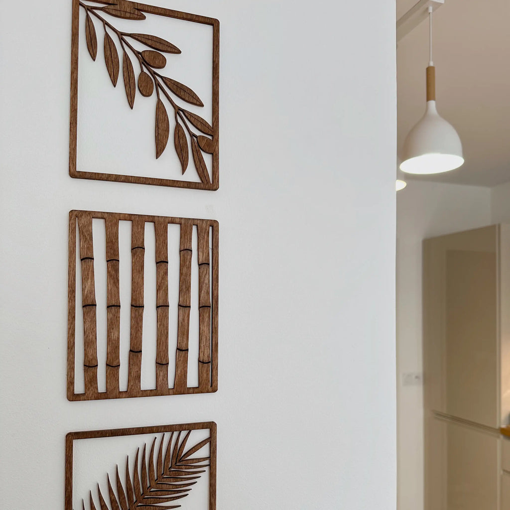 Tableaux en bois modernes qui montrent chacun une branche d'arbre, installés dans un bureau.