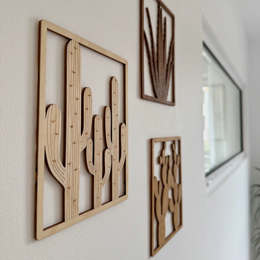 trois tableaux en bois de cactus, opuntia, saguaro et aloe vera, exposés sur mur blanc