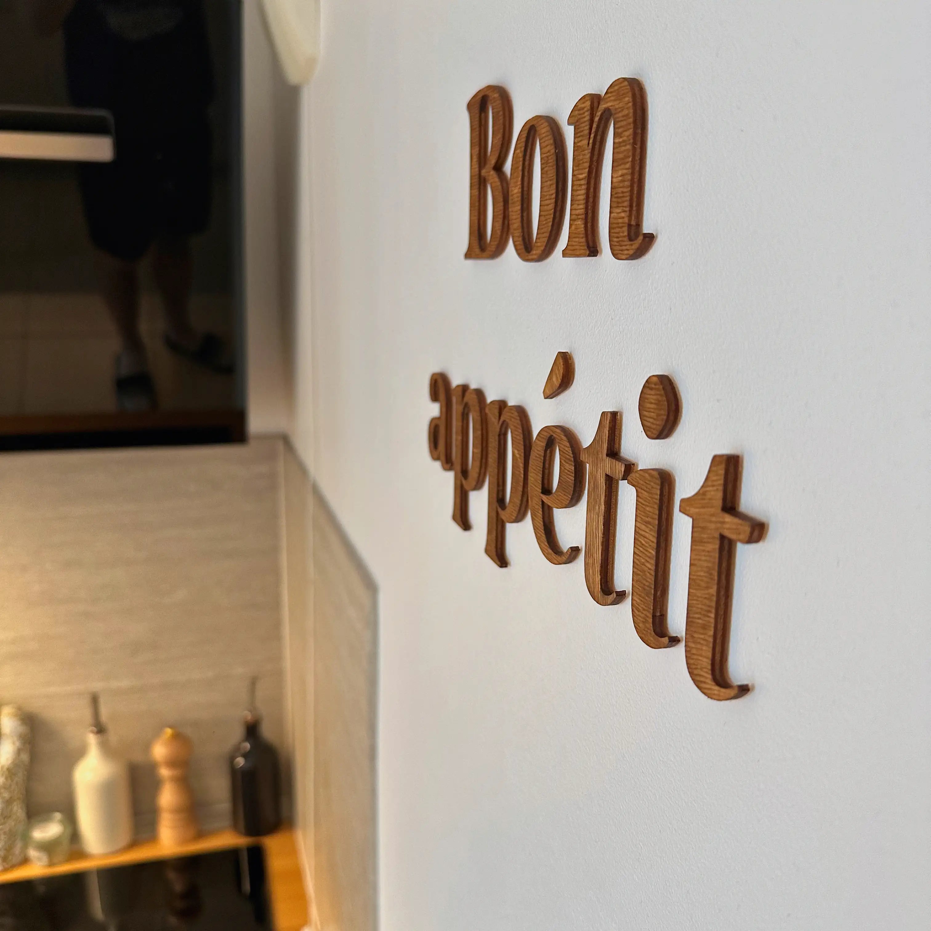 Vue rapprochée de la phrase murale en bois "bon appétit" dans une cuisine