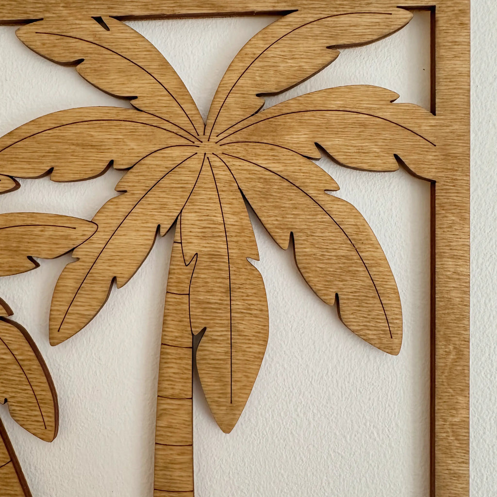 Zoom sur un tableau en bois qui représente un palmier, accroché dans un bureau.