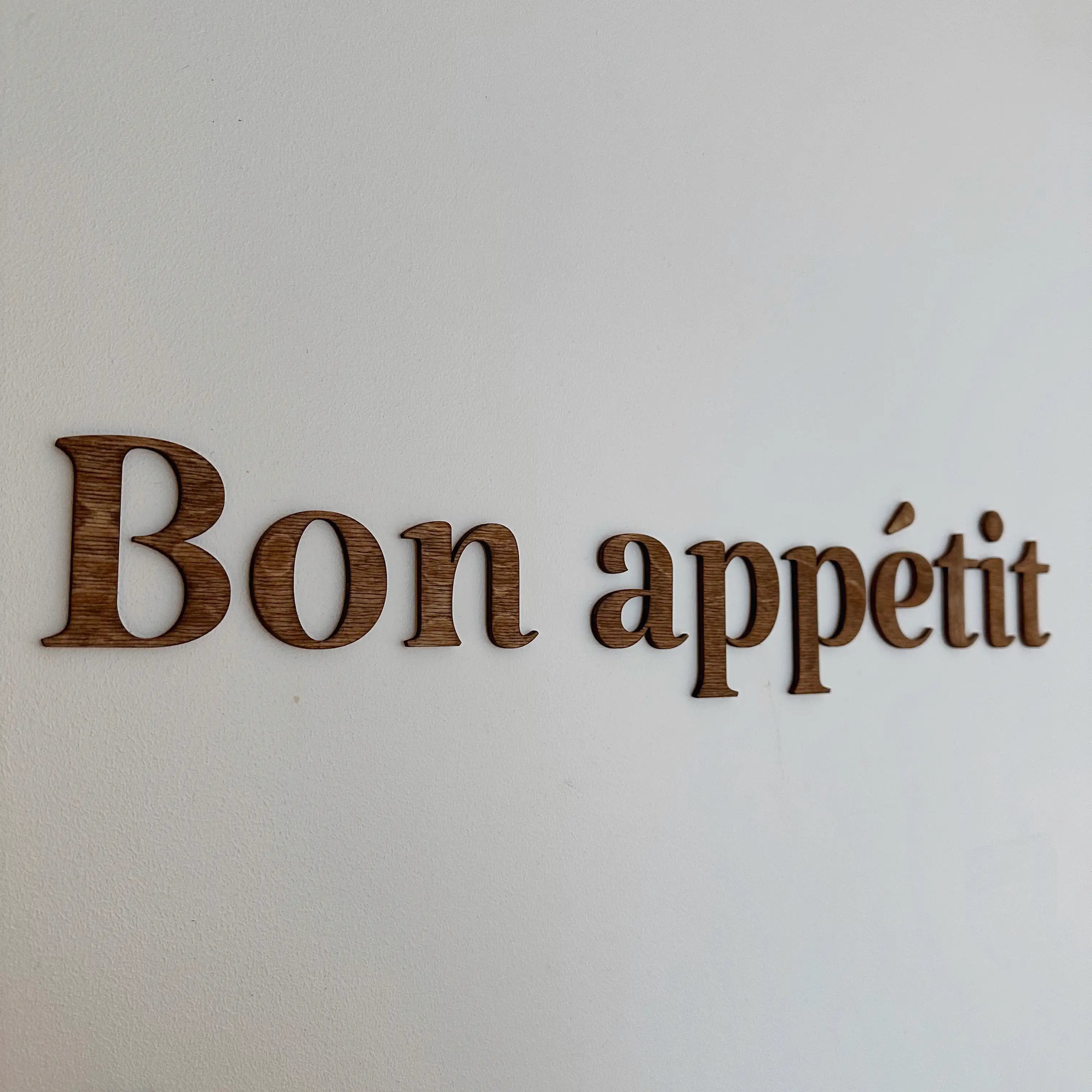 Zoom sur la décoration murale "Bon appétit" dans le coloris chêne foncé