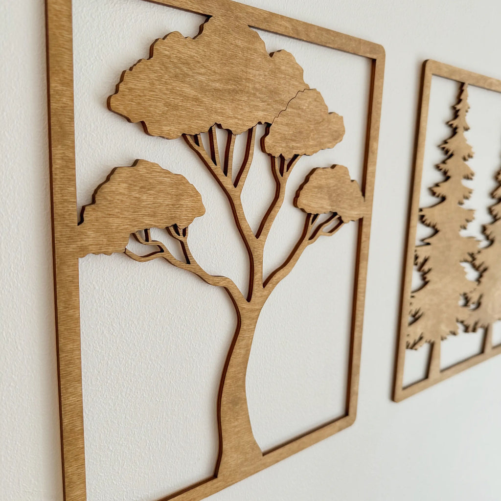 Vue rapprochée d'une décoration en bois qui représente un arbre du désert, sur mur blanc.