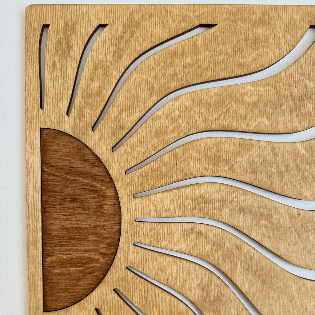 Vue proche du tableau en bois qui représente un lever de soleil, design original.