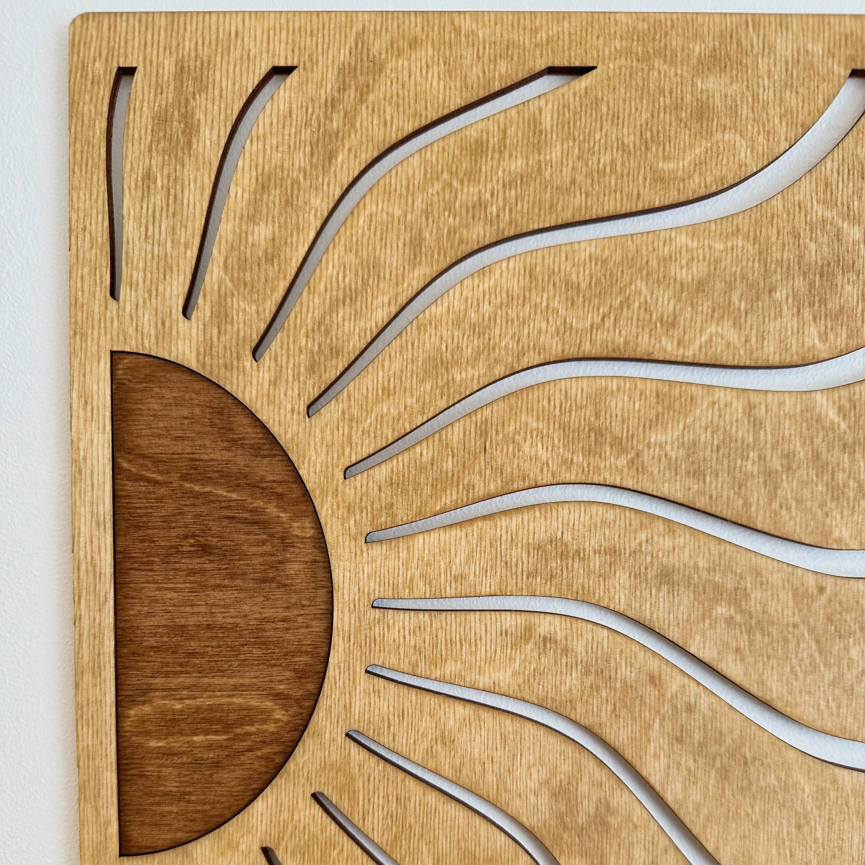 Vue proche du tableau en bois qui représente un lever de soleil, design original.