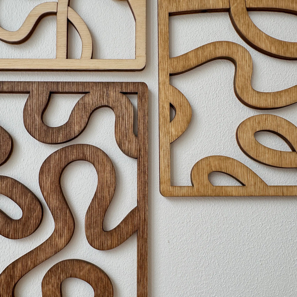 Zoom sur les trois tableaux en bois, courbes qui se croisent, décoration murale originale et moderne.