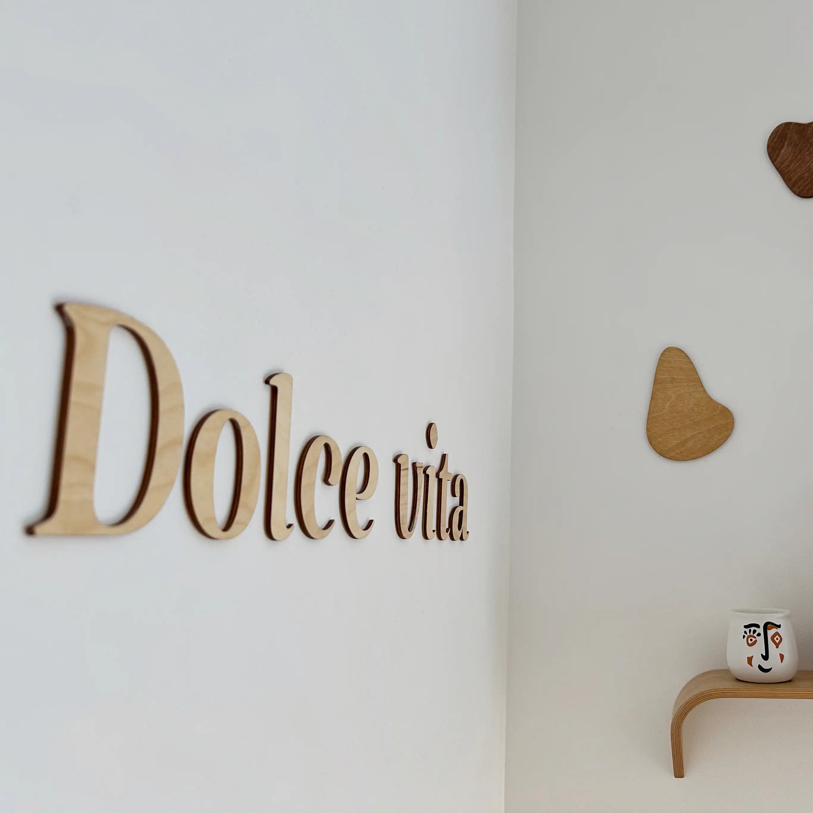 Décoration murale en bois "Dolce Vita" installée dans un salon