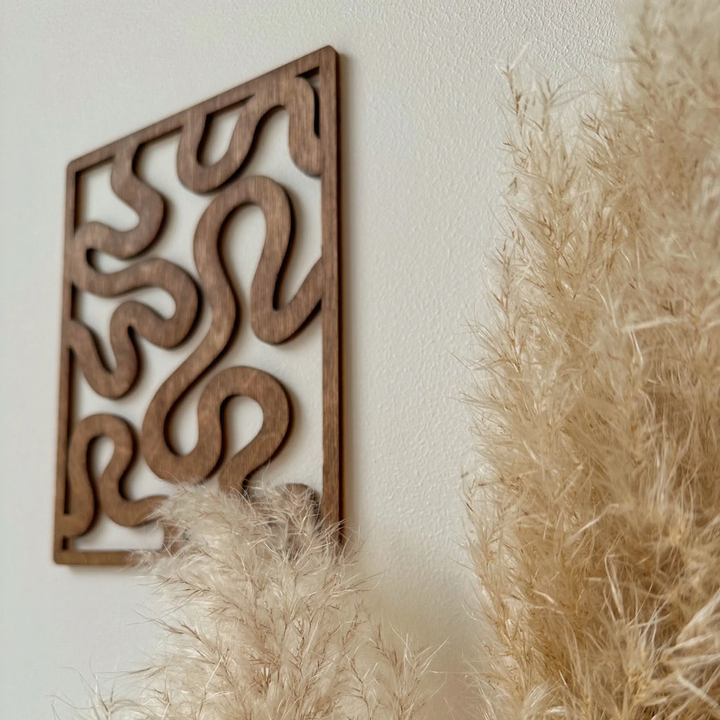 Tableau en bois qui représente une courbe découpée au laser, dans un coloris chêne foncé.