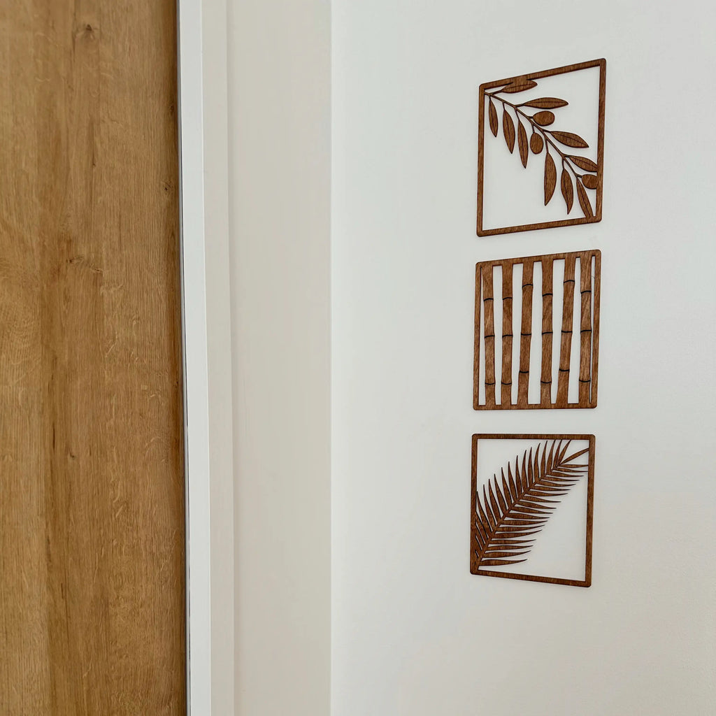 Lot de décorations murales en bois qui représentent chacune un végétal différent, accrochés dans un salon.